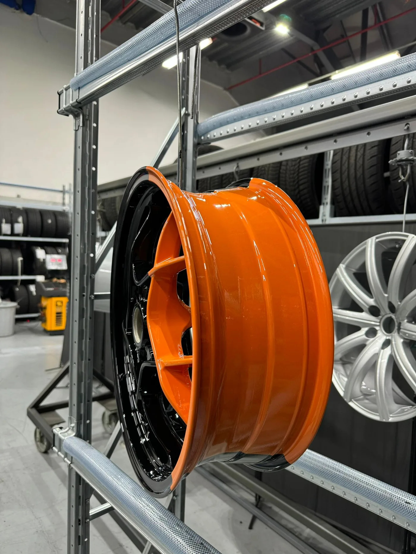 Jante thermolaquée orange suspendue dans l'atelier J9R